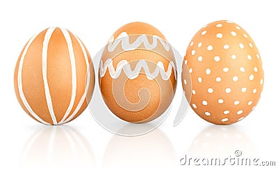 Natural isolated eggs. Three Easter brown eggs decorated with patterns of white paint Stock Photo