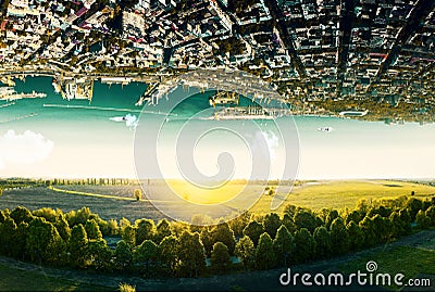 Natural landscape with unreal upside down sityscape. Stock Photo