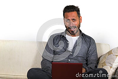 Lifestyle portrait of young handsome and successful self employed man working at home using laptop computer sitting relaxed at Stock Photo