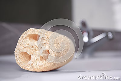 Natural loofah sponge on washbasin in bathroom, closeup Stock Photo