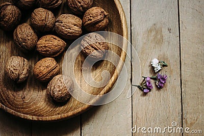 Natural nuts and in a stylish unique rustic bowl on a wooden b Stock Photo