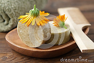 Natural organic calendula solid shampoo pieces, calendula flowers, wooden hair comb and towel. Stock Photo