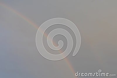 Natural rainbow in the gray overcast sky Stock Photo