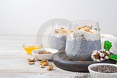 Natural, rich in vitamin, calcium and omega 3 pudding with chia seeds, nuts and honey on a light wooden background. Stock Photo