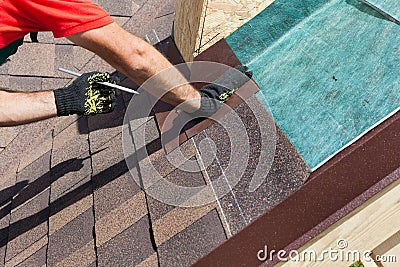 Natural roof tile instaalation. Roofer builder worker marks the distance between the seams. Stock Photo