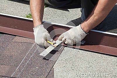 Natural roof tile instaalation. Roofer builder worker marks the distance between the seams. Stock Photo