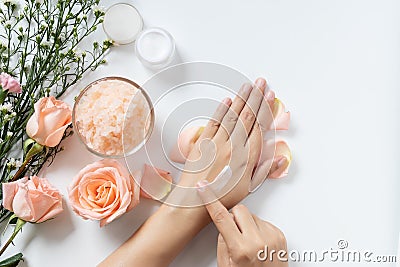 Natural skincare concept. woman apply white cream on her hands on white background with jar of cosmetic cream, salt spa scrub Stock Photo