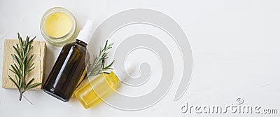 Natural skincare ingredients with floral water bottle, essential oil bottle, rosemary herb, balm and natural soap with copy space Stock Photo