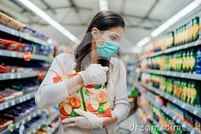 Natural source of vitamins and minerals.Apple juice antioxidants.Woman wearing face mask buying in supermarket.Woman preparing Stock Photo