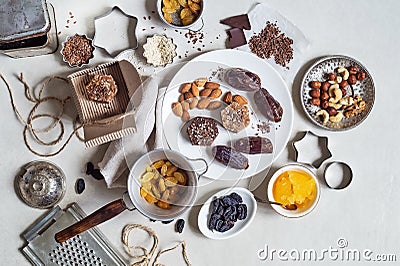 Natural useful sweets from dates, nuts, honey and raisins on a white plate. These ingredients are next on the table Stock Photo