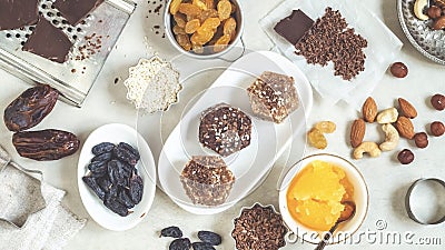 Natural useful sweets from dates, nuts, honey and raisins on a white plate. These ingredients are next on the table Stock Photo