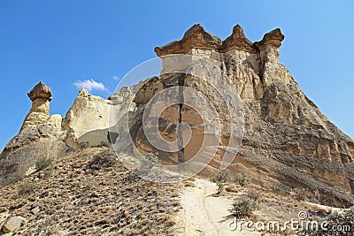 Rocks looking like mushrooms dramatically lit by a sun in Chavushin in Cappadocia, Turkey. Stock Photo