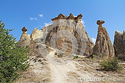 Rocks looking like mushrooms dramatically lit by a sun in Chavushin in Cappadocia, Turkey. Stock Photo