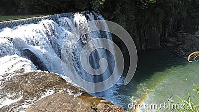 Natural waterfall and tropical green forest with warm sunlight and rainbow reflection at Shifen, Taiwan. Wide aspect ratio of 16:9 Stock Photo