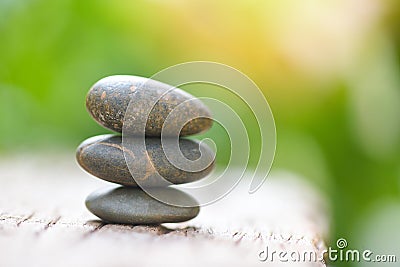 Natural wellness concept - Relax zen stones stack on wooden nature green background Spa Natural Alternative Therapy With Massage Stock Photo