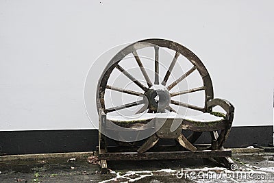 Natural wooden wheel garden seat / bench in snow black, brown and white Stock Photo