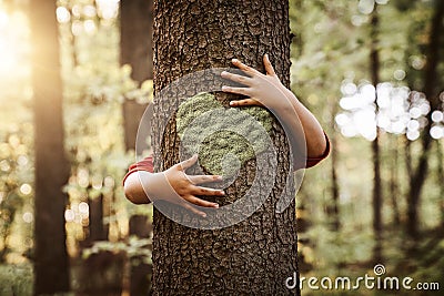 Nature lover, close up of child hands hugging a tree Stock Photo