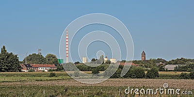 Nature reserve of Rieme, with industrial chimney and wind turbines and church tower in the distance Editorial Stock Photo