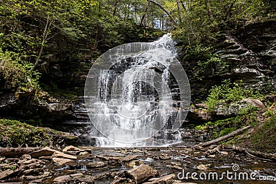 Nature's Staircase: A Grand Pennsylvania Waterfall Cascading Across Multiple Rock Levels Amidst Lush Green Foliage Stock Photo