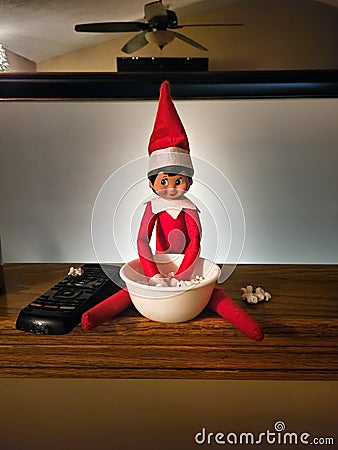 Naught Christmas Elf Eating Popcorn on Christmas Eve Stock Photo