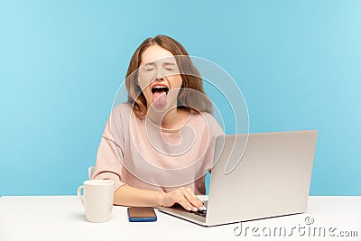 Naughty overworked businesswoman in casual clothes showing tongue out, expressing disgust and disobedience Stock Photo