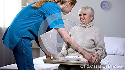 Naughty senior lady refusing disgusting diet dinner in medical center, care Stock Photo