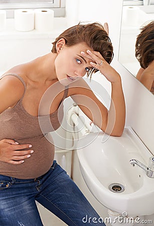 Nausea, pregnant woman and morning sickness in basin unhappy and hand on stomach for discomfort. Exhausted, moody and Stock Photo