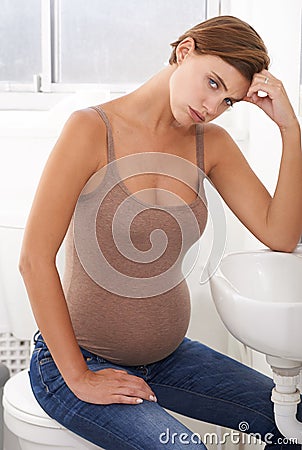 Nausea, pregnant woman and morning sickness in portrait, bathroom and uncomfortable person. Exhausted, moody and Stock Photo