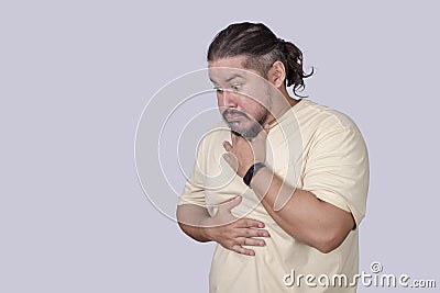 A nauseated man has a gag reflex. Having the urge to vomit. Scene isolated on a gray background Stock Photo