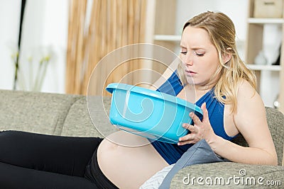 nauseous pregnant woman leaning over bowl Stock Photo