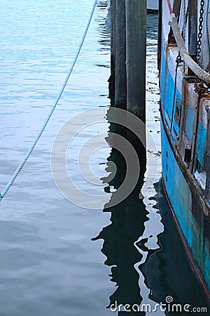 Nautical Abstract of Dock, with Rope, Water, Pier, Blue Boat Stock Photo