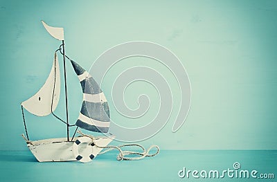 nautical concept with white decorative sail boat over blue wooden table. Vintage filtered image. Stock Photo