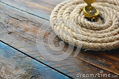 Nautical navigation background. Sea rope with a compass on a wooden desk. Stock Photo