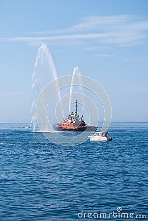 Naval vessel of firefighters with high splashes of sea water Editorial Stock Photo