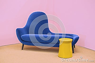 Navy blue sofa on a pink background, laconic interior Stock Photo