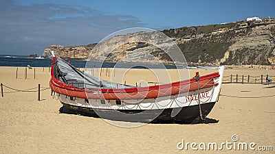 Nazare lifeboat in a beach exhibit by the Dr. Joaquim Monso Museum in collaboration with the Municipality of Nazare, Portugal. Editorial Stock Photo