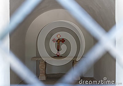 A cross with a crucifix stands on a table in an old chapel in the catholic Christian Transfiguration Church located on Mount Tavor Editorial Stock Photo