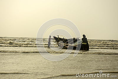 2nd February, 2022, Mandarmani, East Midnapur, West Bengal, India: A wooden lonely fishing boat with few fishermen on Digha sea Editorial Stock Photo