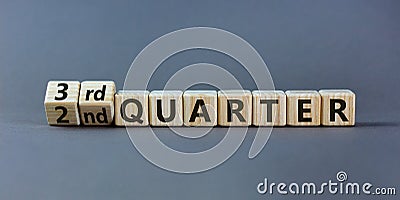 From 2nd to 3rd quater symbol. Turned wooden cubes and changed words `2nd quater` to `3rd quater`. Beautiful grey table, grey Stock Photo