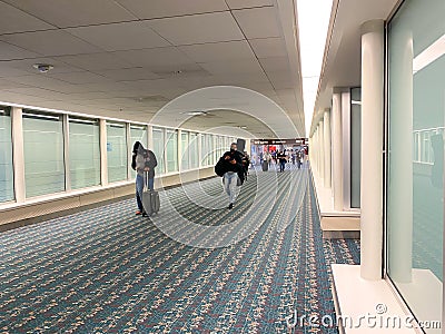 A nearly empty Orlando International Airport with people social distancing and wearing face masks Editorial Stock Photo
