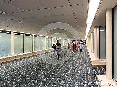 A nearly empty Orlando International Airport with people social distancing and wearing face masks Editorial Stock Photo