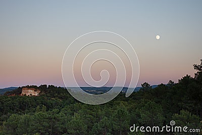 A Nearly Full Moon Over the Ochre Cliffs of Roussillon France Stock Photo