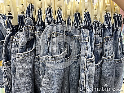 Neat rows of jeans on hangers Stock Photo