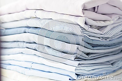 Neatly folded men`s shirts of pastel tones. Stock Photo