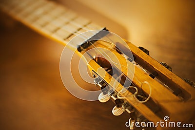 The neck of a beautiful vintage guitar, which lies on a wooden table on a sunny day. Art and music. Solfeggio Stock Photo