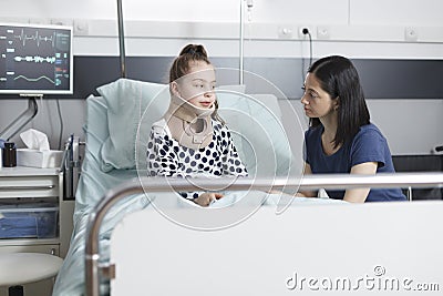Neck injured little girl talking to worried anxious mother about accident Stock Photo