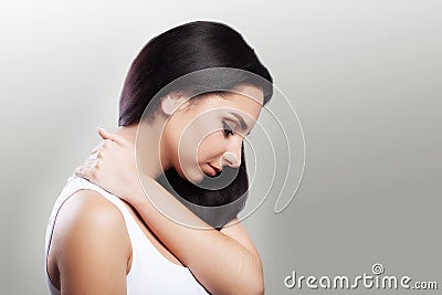 Neck pain. Painful sensations in the neck area. The girl holds her hand to the painful area. Rheumatism The concept of health. On Stock Photo