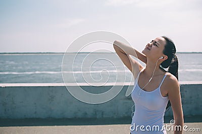 Neck pain during training. Athlete running Caucasian black hair woman runner with sport injury and touching upper back Stock Photo
