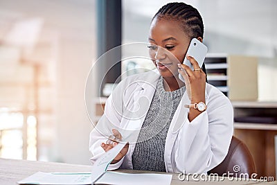 We need to reschedule our appointment. a young female doctor making a phone call using her smartphone. Stock Photo