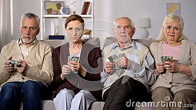 Needy senior people holding money looking camera, financial instability, crisis Stock Photo